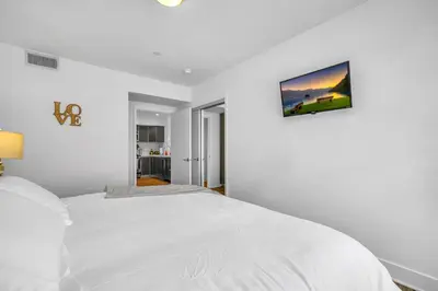 a white bedroom with a bed and a picture on the wall at Amazing, Spacious Unit, Heart LA in Los Angeles