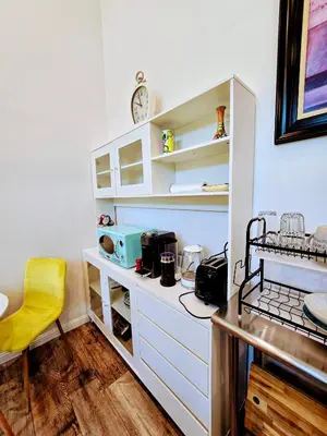 a kitchen with white shelves and a yellow chair at Luxury Guesthouse in Los Angeles
