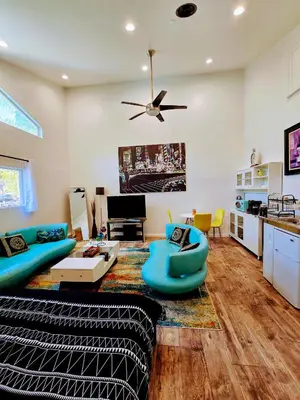 a living room with blue furniture and a ceiling fan at Luxury Guesthouse in Los Angeles