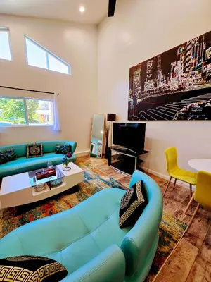 a living room with a blue couch and a tv at Luxury Guesthouse in Los Angeles