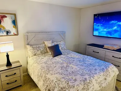 a bedroom with a bed and a tv on the wall at Mid-City Charm 2BR Near LAs Hotspots! in Los Angeles