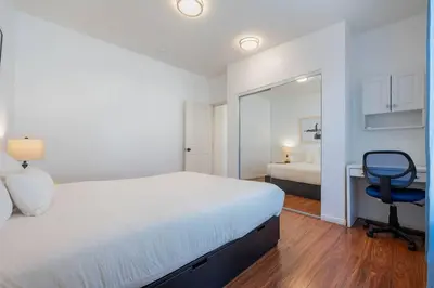 a bedroom with a bed and a desk and a chair at Woodland Victory Hideaway in Tarzana