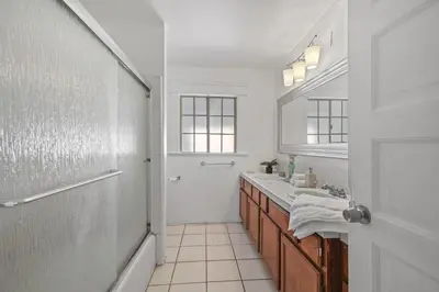 a white bathroom with a sink and a mirror at Spacious Chic 5 Bedroom Perfect for Large Group With parking in Los Angeles