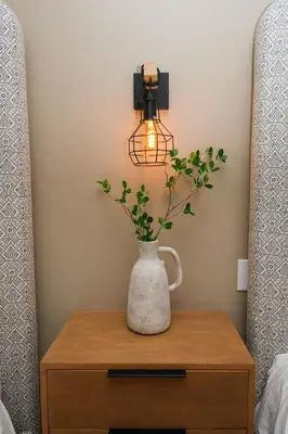 a vase with a plant on a table with a light at Adobe Inn in Monterey Park