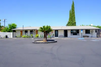 a building with a palm tree in the middle of a parking lot at Adobe Inn in Monterey Park