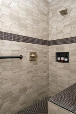 a bathroom with a tiled shower with a soap dispenser at Adobe Inn in Monterey Park