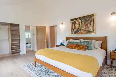 a bedroom with a large bed and a painting on the wall at Walk to Venice Beach from Luxury home in Los Angeles