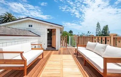 a deck with white couches and a house at Walk to Venice Beach from Luxury home in Los Angeles