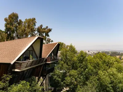 a house on top of a hill with trees at Architectural Marvel in Hollywood Hills with Views in Los Angeles