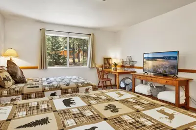 a bedroom with two beds and a desk and a television at Four little bears cabin #2490 in Big Bear Lake