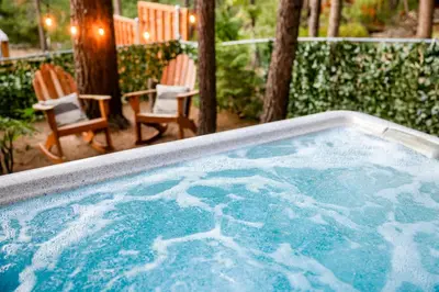 a jacuzzi tub with two chairs in a yard at The nest on towne trail #2480 in Big Bear Lake