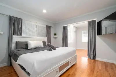 a bedroom with a large bed and a large window at Elegance Escape Sleeps 10 Pool with Jacuzzi in Los Angeles