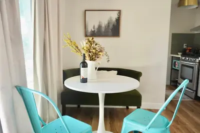 a table with a bottle of wine and two chairs at Sunny Days Tiny House with private entrance, pool and view in West Covina