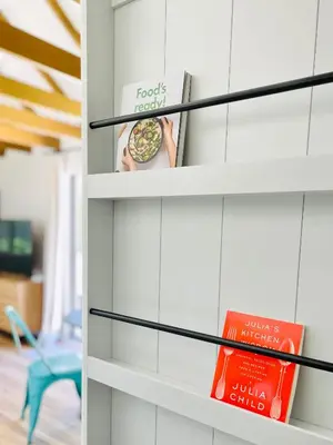 a book shelf with books and a book at Sunny Days Tiny House with private entrance, pool and view in West Covina