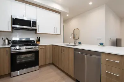 a kitchen with white cabinets and a stove top oven at Stylish Apartments in Glendale with Free Parking in Glendale