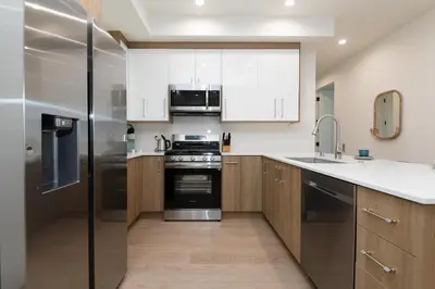 a kitchen with stainless steel appliances and wooden cabinets at Stylish Apartments in Glendale with Free Parking in Glendale