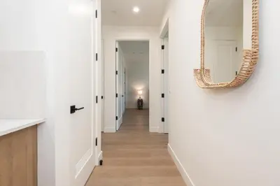 a hallway with white walls and a mirror on the wall at Stylish Apartments in Glendale with Free Parking in Glendale