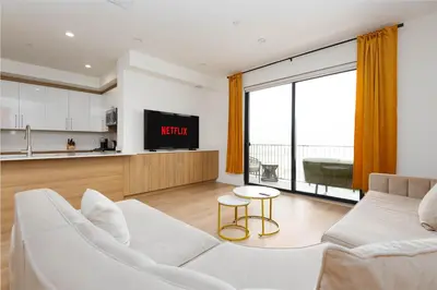 a living room with a white couch and a kitchen at Stylish Apartments in Glendale with Free Parking in Glendale