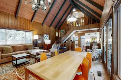 a living room with a wooden table and chairs at Quiet Wooded Retreat in Lake Arrowhead