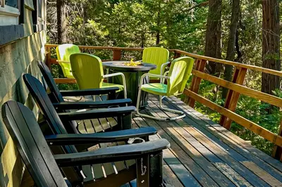 a group of chairs and a table on a deck at Quiet Wooded Retreat in Lake Arrowhead