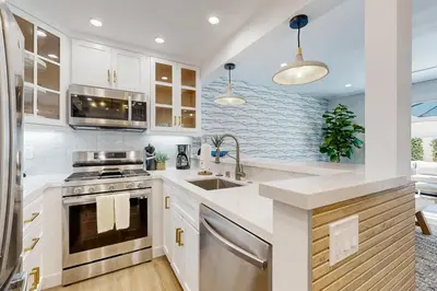 a kitchen with white cabinets and a sink at Mickey's Hideaway in Anaheim