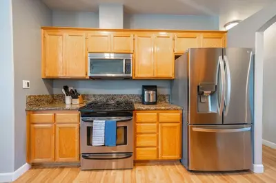 a kitchen with stainless steel appliances and wooden cabinets at Central Bliss near parks & shops in Bakersfield
