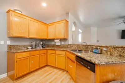 a kitchen with wooden cabinets and a counter top at Central Bliss near parks & shops in Bakersfield