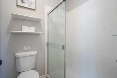 a bathroom with a toilet and a glass shower at Central Bliss near parks & shops in Bakersfield