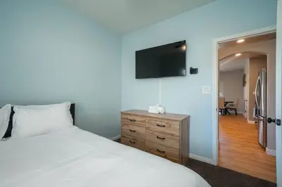 a bedroom with a bed and a television on the wall at Central Bliss near parks & shops in Bakersfield