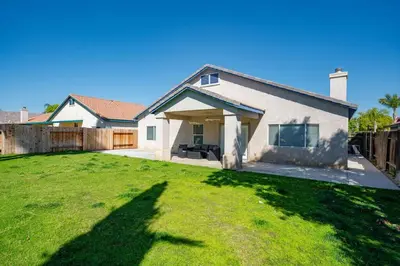 a house with a large lawn in front of it at Central Bliss near parks & shops in Bakersfield