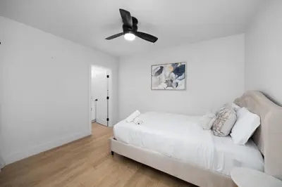 a living room with a white couch and a ceiling fan at NEW Lux 5BR Villa Near Disney, Knotts, LA, OC with Hot Tub & Games in Fullerton