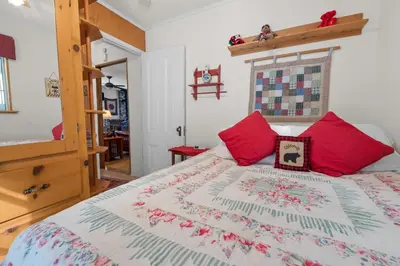 a bedroom with a bed with red pillows at Cozy Bear Cottage - Walk to Lake & Village! in Big Bear Lake