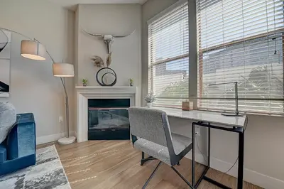 a room with a desk and a chair and a fireplace at Penthouse One Bedroom Garden View Condo by UCLA in Los Angeles
