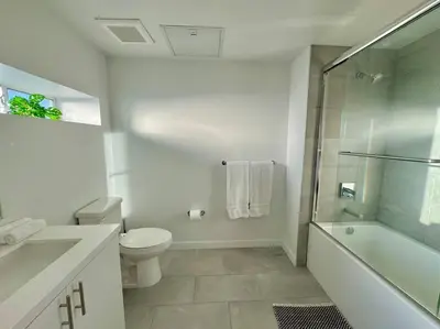 a white bathroom with a toilet and a shower at Corner 2 Bedroom 2 Bath Condo - Balcony - Parking in Los Angeles