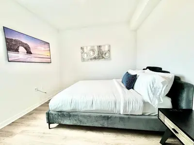 a white bedroom with a bed and a table at Corner 2 Bedroom 2 Bath Condo - Balcony - Parking in Los Angeles