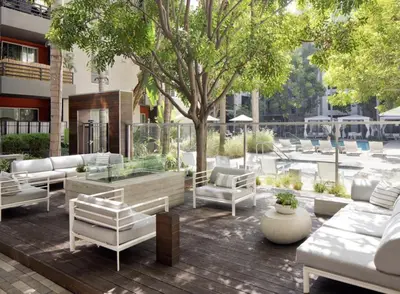 a patio with white furniture and a tree and a building at Stunning 2BD 2BTH Apt in Santa Monica! in Los Angeles