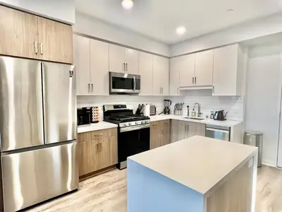 a kitchen with stainless steel appliances and wooden cabinets at Designer Silver Lake Stylish One Bedroom with Parking in Los Angeles