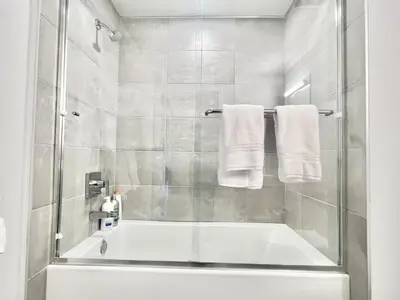 a bathroom with a tub and a shower with towels at Designer Silver Lake Stylish One Bedroom with Parking in Los Angeles