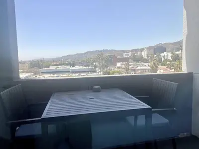 a table and chairs on a balcony with a view at Luxe Corner One Bedroom, Prime Hollywood with Parking in Los Angeles