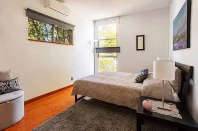 a bedroom with a bed and a table and a window at Lovely one bedroom guest house in Encino village in Los Angeles