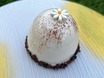a cake on a plate with a flower on it at Party House Heaven in North Hollywood