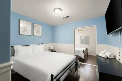 a bedroom with blue walls and a bed with white sheets at Perfect Home for Work or Relaxing Vacation in Bakersfield