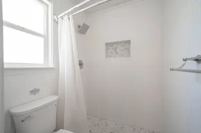 a white bathroom with a toilet and a shower at Simple Home for Work or Travel in Bakersfield