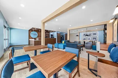 a lobby with tables and chairs and a waiting room at Everhome Suites Ontario in Ontario