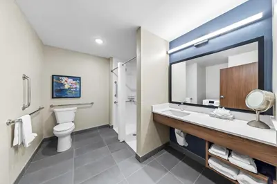 a bathroom with a toilet sink and a mirror at Everhome Suites Ontario in Ontario