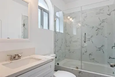 a white bathroom with a shower and a sink at Lovely gated 3bedroom & 2 bath unit near Universal studio and Hollywood in North Hollywood