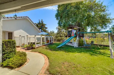 a playground in a yard next to a house at Pet-Friendly Riverside Retreat with Private Spa! in Riverside
