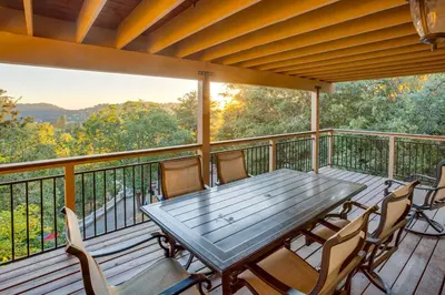 a wooden deck with a table and chairs on it at Lake Arrowhead Cabin 4 Decks, Game Room and More! in Lake Arrowhead