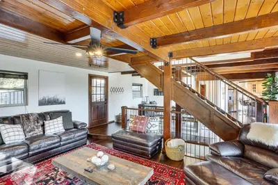 a living room with leather furniture and a staircase at Lake Arrowhead Cabin 4 Decks, Game Room and More! in Lake Arrowhead