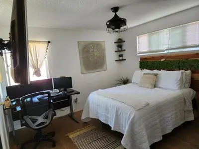 a bedroom with a bed and a desk and a computer at The Coastal Comfort in Oxnard
